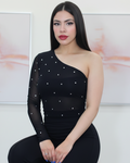 Woman wearing a black one-shoulder outfit with silver embellishments.